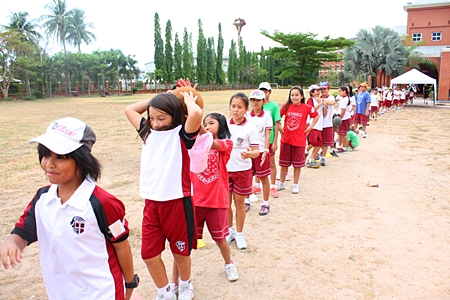 The line of children playing tunnel ball stretches to the horizon.